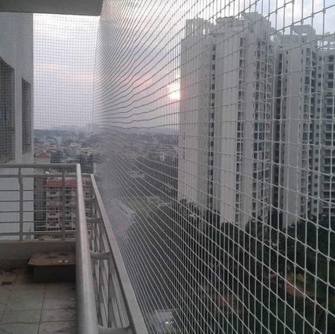White safety net installed on a high-rise apartment balcony