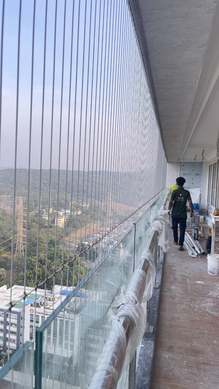 Installer completing an invisible grille installation on a high-rise balcony