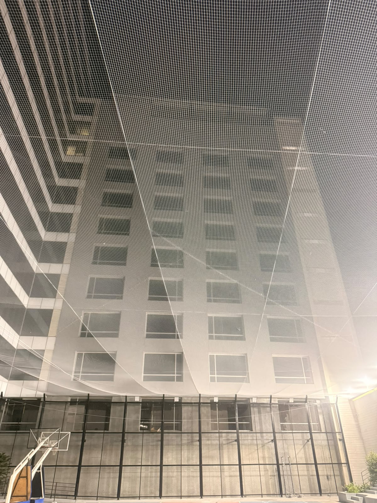 Overhead net stretched above an open courtyard between buildings
