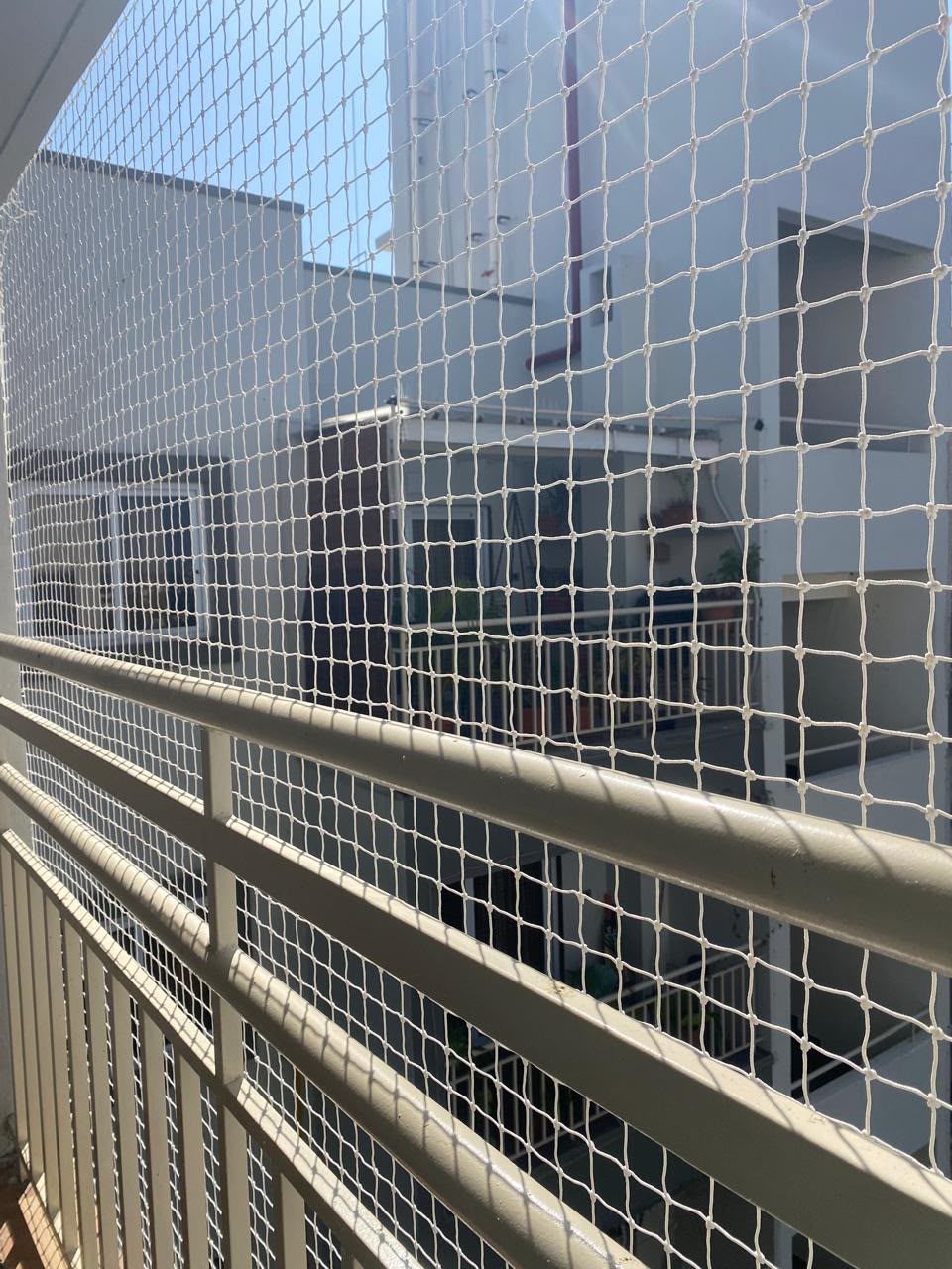 Close view of a white knotted safety net on a balcony